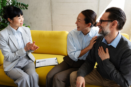 Happy couple reacting positively while talking with a real estate agent after viewing a property, excited about finding their potential new home.