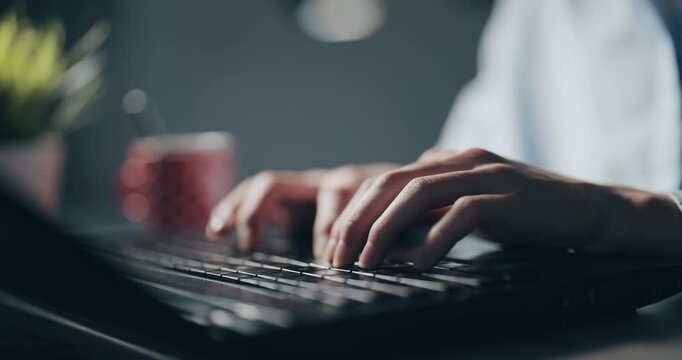 A person is typing on a laptop with a cup of coffee next to them. Concept of productivity and focus, as the person is working on their computer while enjoying a hot beverage, cinematic isolated shot