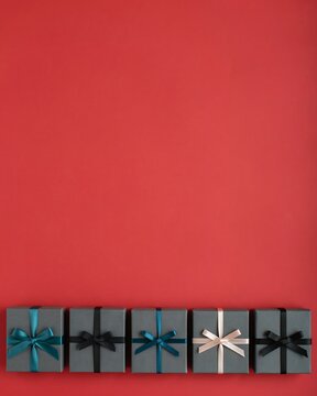 Row of colorful gift boxes with ribbons on a vibrant red background