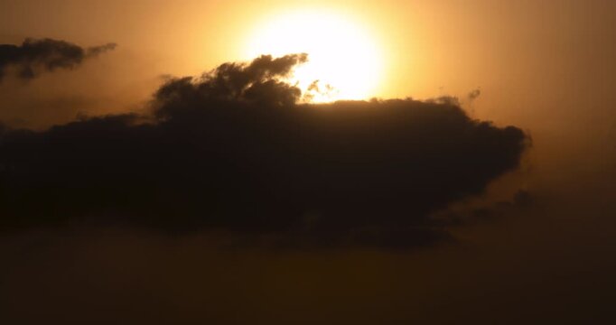 Timelapse of the sun setting behind thick clouds