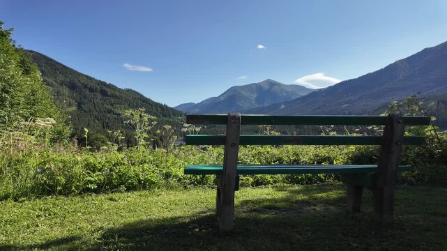 Scenic view of a wooden bench overlooking majestic mountains in Styria, Austria