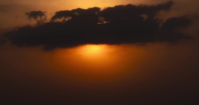 Timelapse of the sun setting behind thick clouds