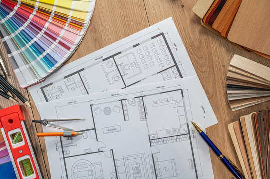 Top View of House Floor Plan Draft with Wooden Material Samples and Color Swatch Palette Books