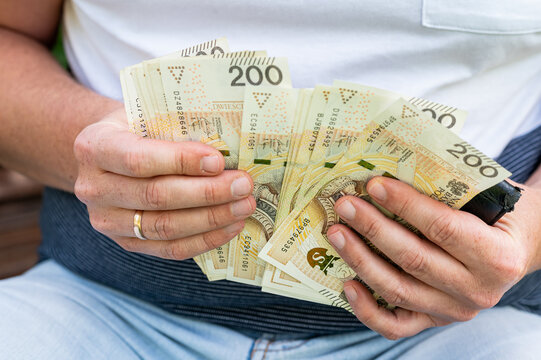 Male Hands Holding and Counting Large Stack of Polish 200 Zloty Bills for Business Finance