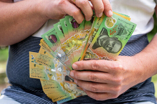 Male Hands Holding and Counting Stack of Australian Dollar Bills for Business Finance Concept