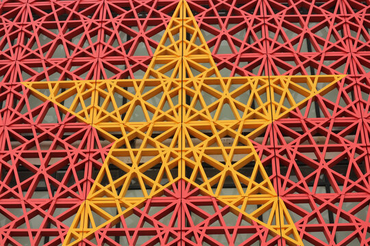 Vietnam national flag abstract geometric background front view, stylized gold star on red structural wall facade pattern for Vietnamese patriotic concept