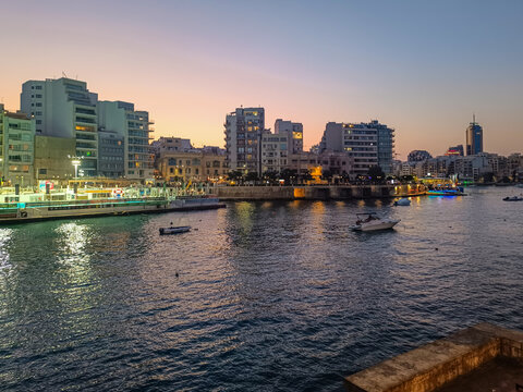 Lights reflected on the sea from terraces and modern buildings in Balluta Bay, St. Julian's MALTA