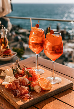 Exciting orange Italian spritz cocktails served with a charcuterie plate, Sanremo, Italy