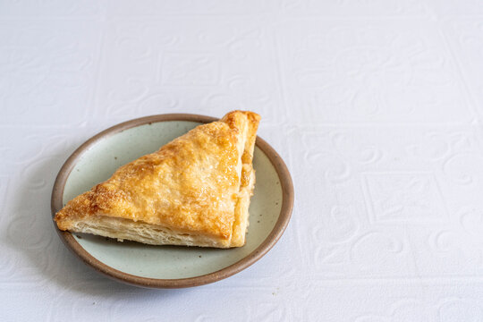 Apple turnovers on a plate with a white tile surface 