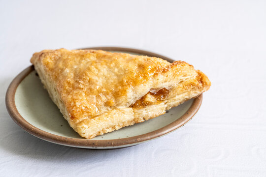 Apple turnovers on a plate with a white tile surface 