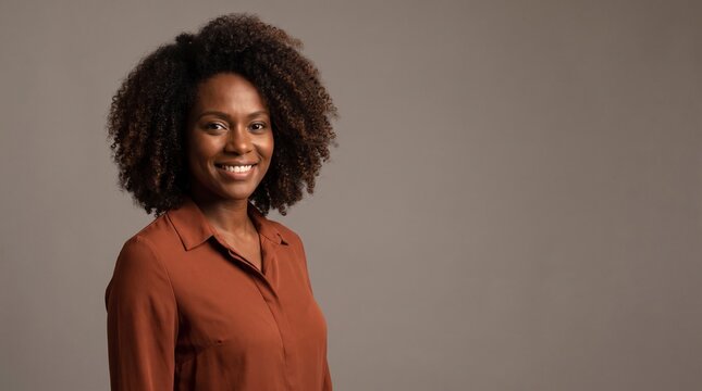 Portrait of a confident smiling African American woman with curly hair on grey background