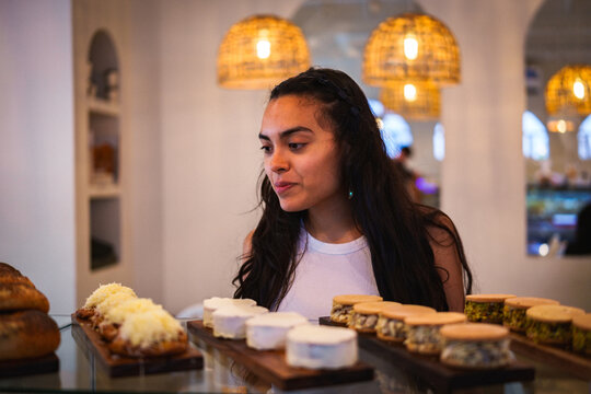 Mujer observando la pasteler&iacute;a en una cafeter&iacute;a