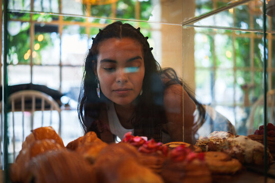 Mujer observando la pasteler&iacute;a en una cafeter&iacute;a