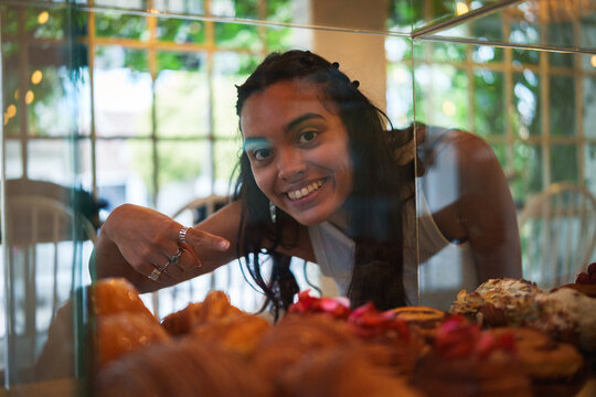 Mujer observando la pasteler&iacute;a en una cafeter&iacute;a