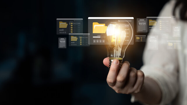 A creative representation of innovation featuring a light bulb held in a hand, surrounded by digital folders, symbolizing the fusion of ideas and technology in modern work. Ledger