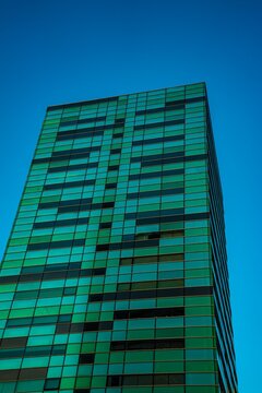 Modern Glass Skyscraper Against Blue Sky