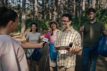 Obraz premium Volunteers giving news interview about forest cleanup efforts