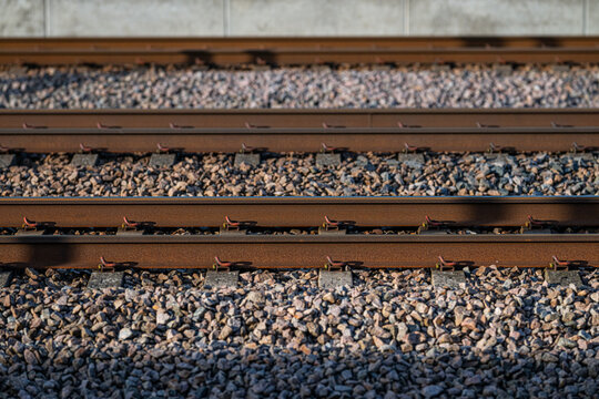 Close up pattern of parallel railway rails on gravel ballast.