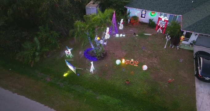 Holiday decorations brighten the lawn and front porch of a Florida home, vibrant Christmas spirit at night.
