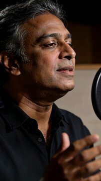 Vertical video: Singing singer starting open note in studio booth, collared shirt to show feeling