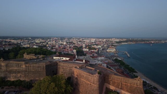 Aerial drone view of Set&uacute;bal, Portugal, showing the city, S&atilde;o Filipe Fort, Arr&aacute;bida Mountains, Sado Estuary, sea, ships and Tr&oacute;ia Peninsula. Panoramic Portuguese coastal landscape featuring the city,