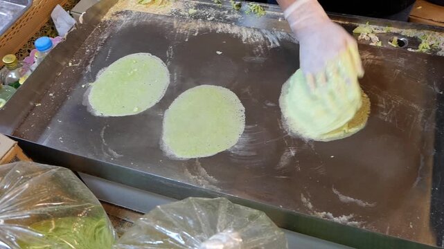 Making thin roti sheets for Thai snack of Roti Sai Mai, Thailand