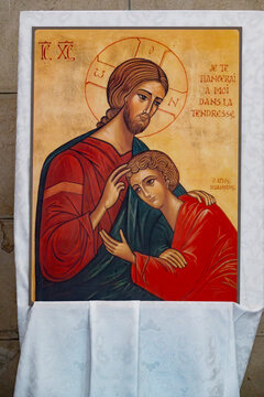 A painted religious icon depicts Jesus Christ embracing Saint John.