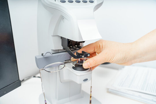 A female optician measures and selects glasses using a state-of-the-art digital device at an optical store.