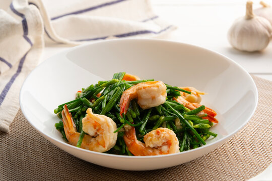 Stir-Fried Shrimps with Chinese Chives flower in white plate.