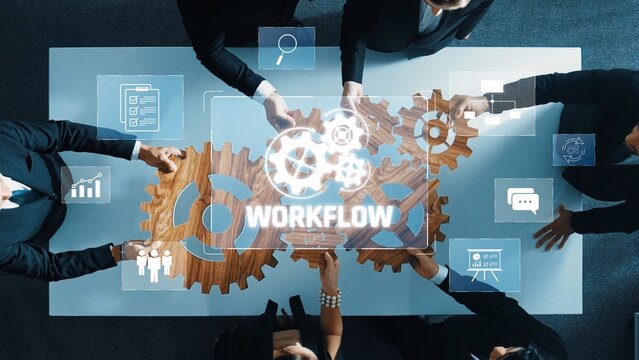 A group of professionals collaborates in an office setting, utilizing gears and digital graphics to enhance workflow management, focusing on efficiency and teamwork. Raster