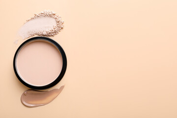 Swatches of foundation and face powder on beige background, flat lay. Space for text