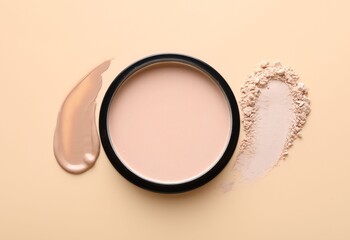 Swatches of foundation and face powder on beige background, flat lay