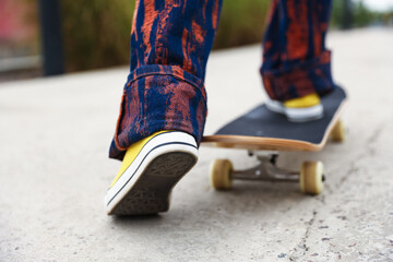 Woman riding skateboard on city street, closeup © New Africa