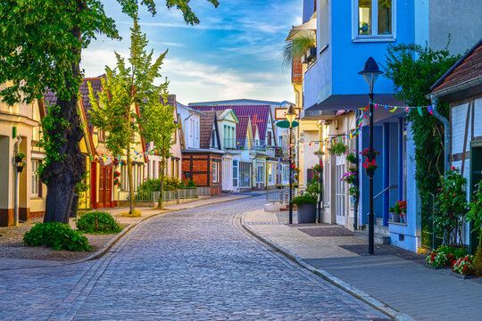 Colorful cobblestone street in Warnem&uuml;nde (Rostock) with charming houses and summery decorations.