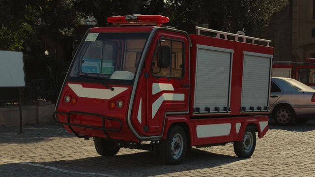 BAKU, AZERBAIJAN - SEPTEMBER 06, 2026: A miniature red fire engine vehicle designed for narrow streets is parked on cobblestones in the historic center of the Old City