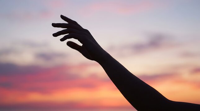 Human arm reaching towards the sky at sunset in a hopeful gesture with reaching silhouette inspiration uplifting