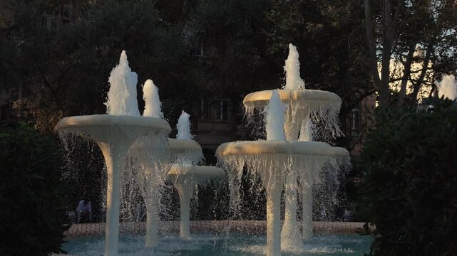 Beautiful white tiered fountain splashing water in a city park