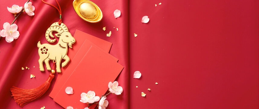 Chinese New Year flat lay with golden goat ornament and red envelopes. Lunar New Year background with copy space