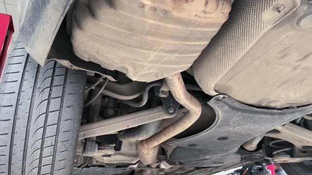 The underside of a car is shown with a lot of dirt and grime. The car is old and has been neglected for a long time. Concept of abandonment and neglect