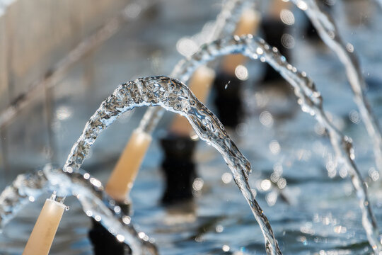 Splashes and jets of water against light background.