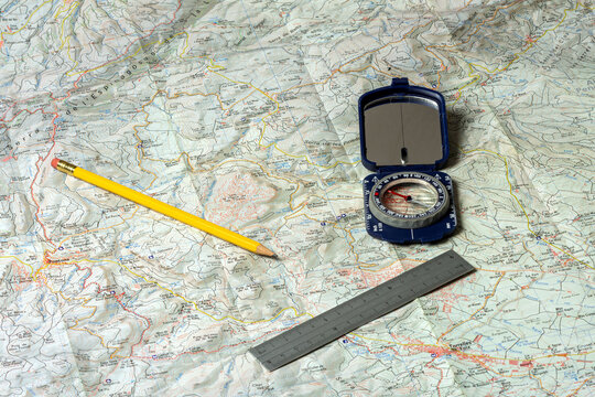 Planning a hiking route with map, compass, ruler, and pencil