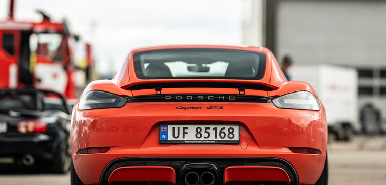 Kristiansand, Norway - June 14 2026: Orange Porsche Cayman GTS rear view at car event.