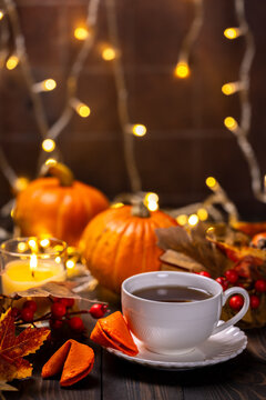 Warm tea cup on table with pumpkins and autumn decorations
