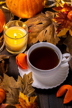 Warm autumn tea with candle and fall leaves