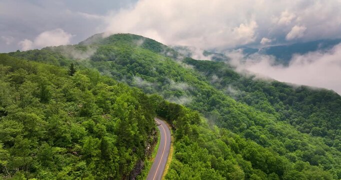 Road trip travel in Appalachian mountains. Car driving on parkway through woods nature in summer wet rainy season. Colorful forest in Tennessee.