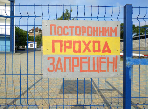 No entry for outsiders - translation from Russian. information sign on a fence with a sign prohibiting outsiders from entering. fence or enclosure. private or guarded territory