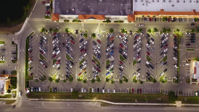 Suburban shopping plaza with parking rows and crowded car spaces. Weekend rush, retail activity and community lifestyle concept.