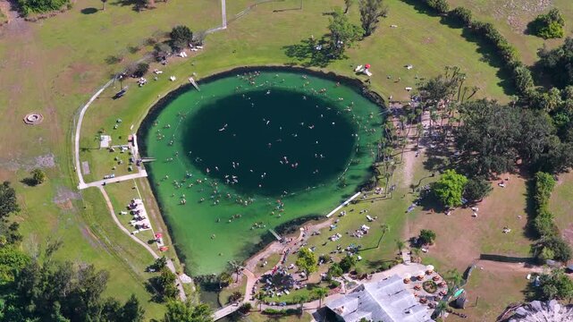 Warm mineral springs attraction with calm turquoise water, swimmers, and sunlit landscape, representing recreation, tourism, and holistic health treatments.