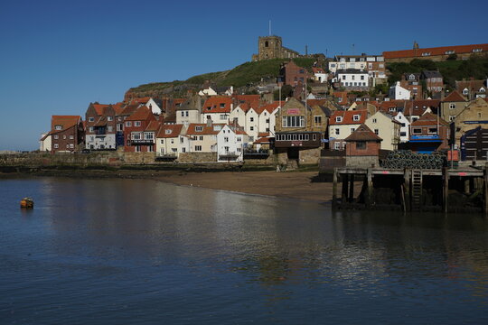 Historic red-roofed cottages and Church of St Mary on the East Cliff above Whitby Harbour, North Yorkshire, England