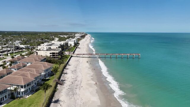 Aerial view of Vero Beach oceanfront homes and pier on a sunny day in Vero Beach in Indian River County, Florida.